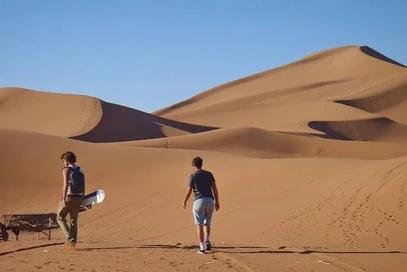 Travellers walking across the Namib dunes