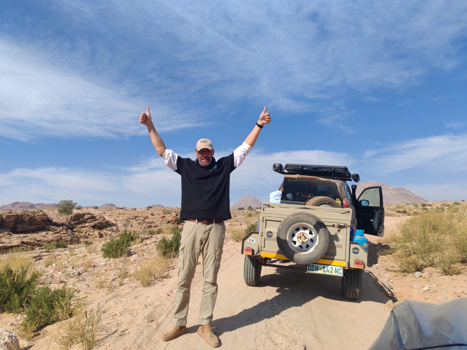 Why Not Africa guide beside a 4x4 vehicle